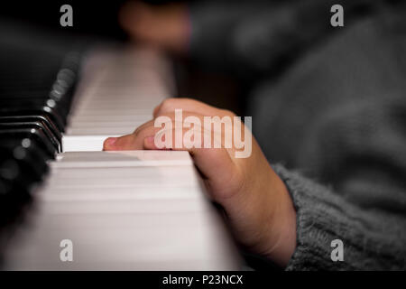 children's hands playing on the keys of the piano closeup Stock Photo