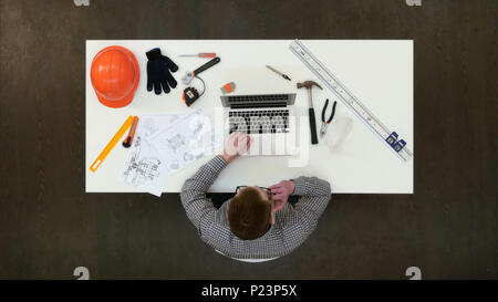 Architect in office working on laptop and answering phone calls Stock Photo