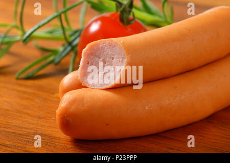 thin wiener sausages on wooden cutting board - detail Stock Photo