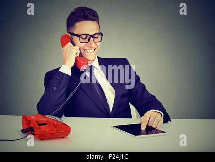 Happy business man using tablet computer having pleasant conversation on the phone Stock Photo