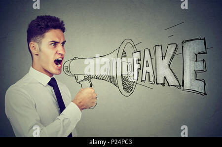 Business man screaming in a megaphone spreading fake news Stock Photo