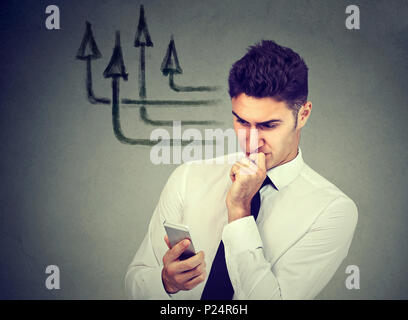 Thoughtful man using mobile phone texting sending messages Stock Photo