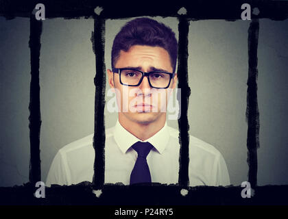 Sad young business man in prison Stock Photo