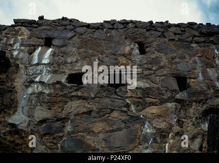 Facade of gray stones with windows in old mining construction with sky background, Spain Stock Photo