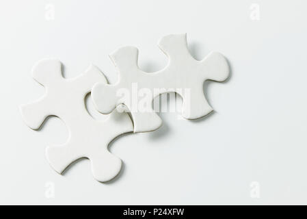 Two pieces of white jigsaw puzzle Stock Photo