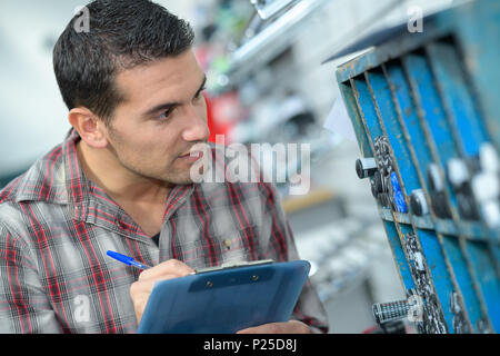 engineer taking notes at control room in factory Stock Photo