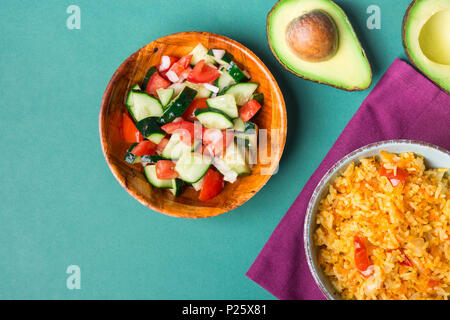 Traditional National Mexican Tomato Rice Stewed Pilaf with Hot Chili Peppers Garlic in Turquoise Bowl. Fresh Cucumber Onion Salsa Salad Avocado for Gu Stock Photo