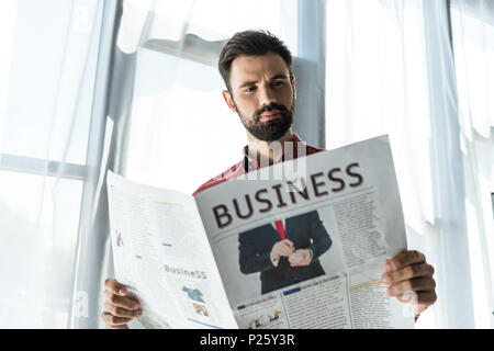 bottom view of handsome young businessman reading newspaper Stock Photo