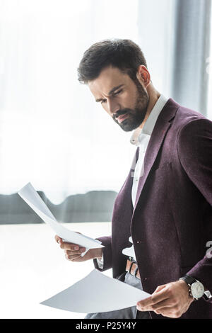 side view of handsome young businessman doing paperwork Stock Photo