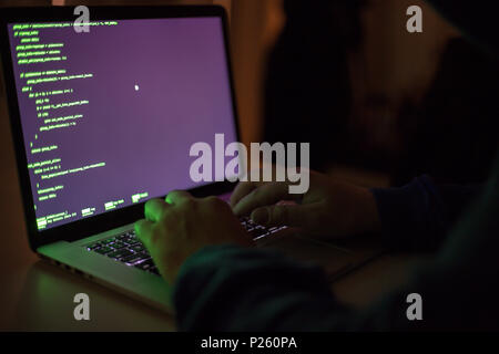 Cybercrime, a laptop hacker, writes codes to access unauthorized things, an illegal way, hacker, crime, cyber Stock Photo