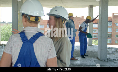 Young architecture and female worker talking at open air construction site Stock Photo
