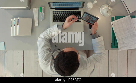 Doctor Videochatting With Senior Colleague On Tablet. Top view Stock Photo