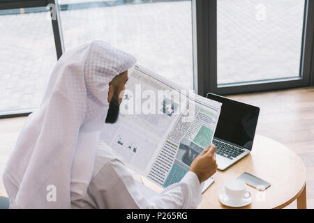 muslim businessman reading newspaper in modern office Stock Photo