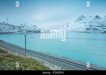 Railway on the shore of Lago Bianco, Bernina Pass, canton of Graubunden, Engadine, Switzerland Stock Photo