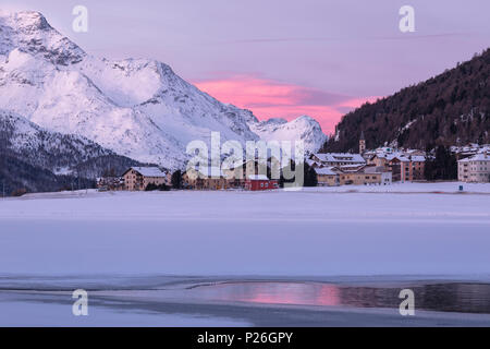 Village of Silvaplana and Piz Da La Margna seen from icy Lake Champfer, St.Moritz, canton of Graubunden, Engadin, Switzerland Stock Photo