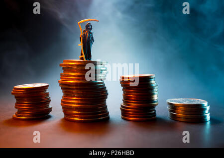 Grim reaper with pile of cash symbolizing the evil of money Stock Photo