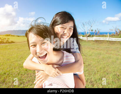 teenager girls playing piggyback and having fun Stock Photo