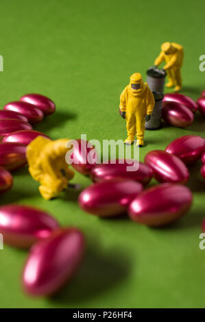 Miniature hazmat team inspects hazardous pain killer pills Stock Photo