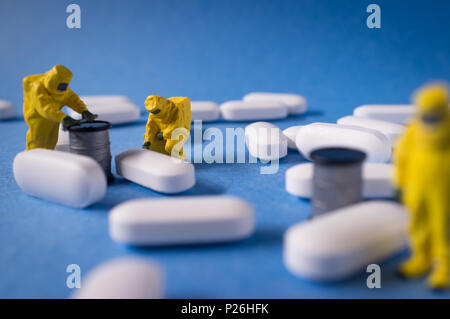 Miniature hazmat team inspects hazardous pain killer pills Stock Photo