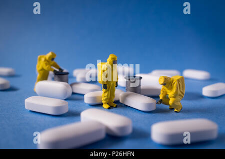 Miniature hazmat team inspects hazardous pain killer pills Stock Photo