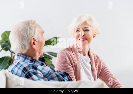 beautiful senior couple sitting on couch at home and talking Stock Photo
