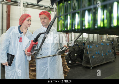 two positive workers in white coats on beer brewery factory Stock Photo
