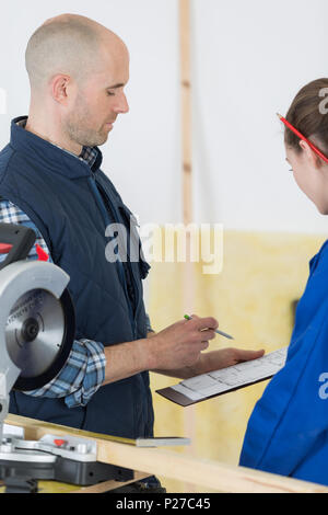 student and teacher in carpentry class using circular saw Stock Photo