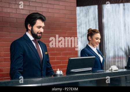 hotel receptionists working with computers together at counter Stock Photo
