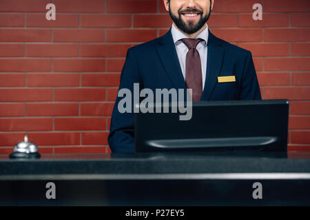 cropped shot of smiling bearded hotel receptionist at workplace Stock Photo
