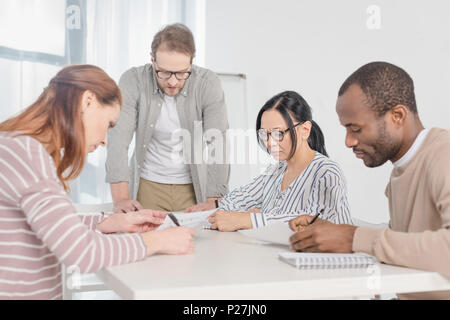 multiethnic middle aged business people working with papers together Stock Photo
