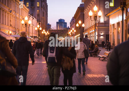 Moscow, Russia - September 21, 2017: People and historical building decorated by warm light at Arbat walking street during twilight. Stock Photo