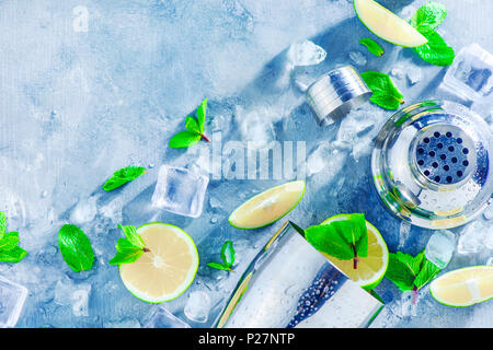 Shaker and bar accessories flat lay. Fresh mojito cocktail ingredients, mint, lime and ice cubes on a gray stone background. Summer drink concept with Stock Photo