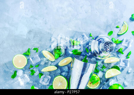 Shaker and bar accessories flat lay. Fresh mojito cocktail ingredients, mint, lime and ice cubes on a gray stone background. Summer drink concept with Stock Photo