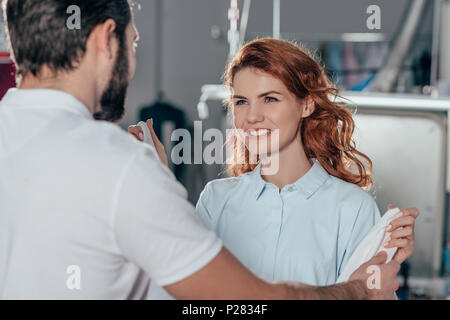 young happy dry cleaning workers at warehouse Stock Photo