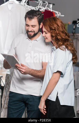 dry cleaning workers using tablet together at warehouse Stock Photo