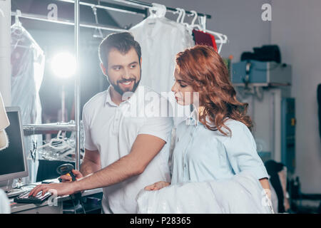 dry cleaning workers using computer and barcode scanner Stock Photo