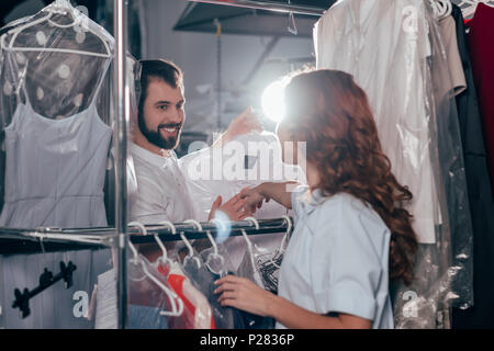 young dry cleaning workers talking at warehouse Stock Photo