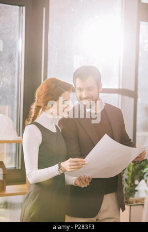 two architects working with blueprint in office with back light Stock Photo