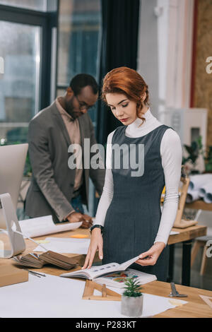 female architect working in office, african american colleague behind Stock Photo