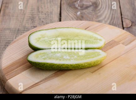Rustic style. Salt falls on the halves of fresh cucumber Stock Photo