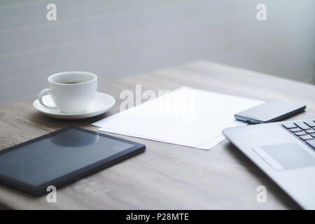 Blank office desk with coffee cup tablet smartphone laptop computer in working space Stock Photo