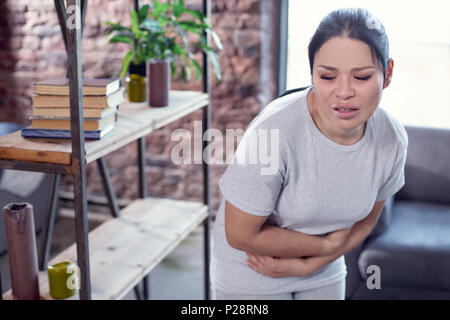 Stressed miserable woman suffering from nauseas Stock Photo