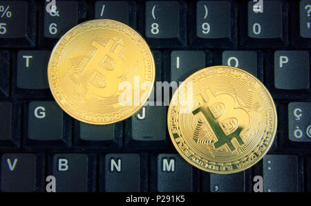 Two golden bitcoins on a computer keyboard. Stock Photo