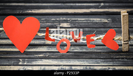 the inscription, like red paper with hearts on rope on wooden background Stock Photo