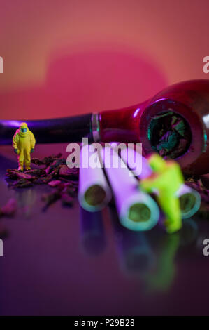 Miniature hazmat team inspects hazardous tobacco products Stock Photo