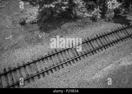 Black and white train tracks beside bridge landscape Stock Photo