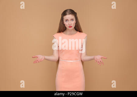 why did you do that? sad woman looking at camera. portrait of emotional cute, beautiful woman with makeup and long hair in pink dress, studio shot, is Stock Photo