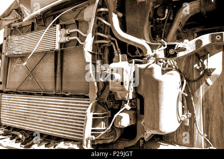 Old broken and dirty car engine close up, view under the hood in sepia tones Stock Photo
