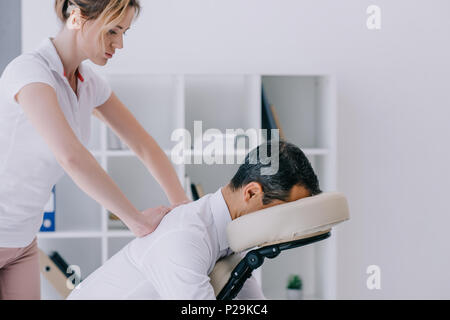 Masseuse Doing Seated Shoulder Massage For Businessman Stock Photo, Picture  and Royalty Free Image. Image 114325390.