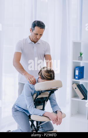 Masseuse Doing Seated Shoulder Massage For Businessman Stock Photo, Picture  and Royalty Free Image. Image 114325390.